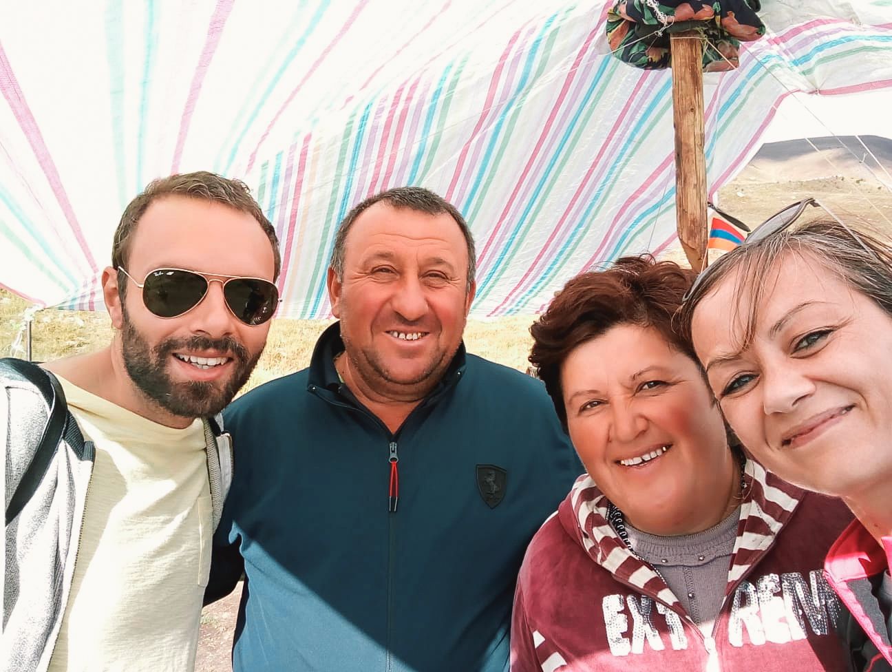 Selfie di viaggiatori sorridenti con sfondo colorato durante un tour in Armenia.